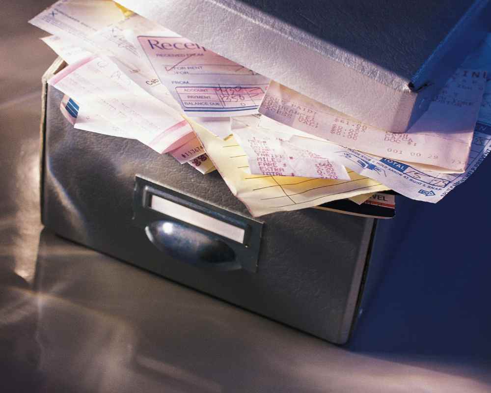Belege in einer Schuhschachtel. Davor ein gezeichneter Mann mit Fragezeichen.